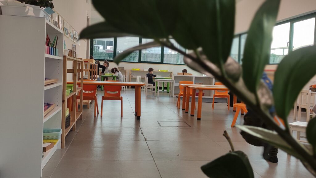 Bambini al lavoro con materiali montessori. Ambiente classe.