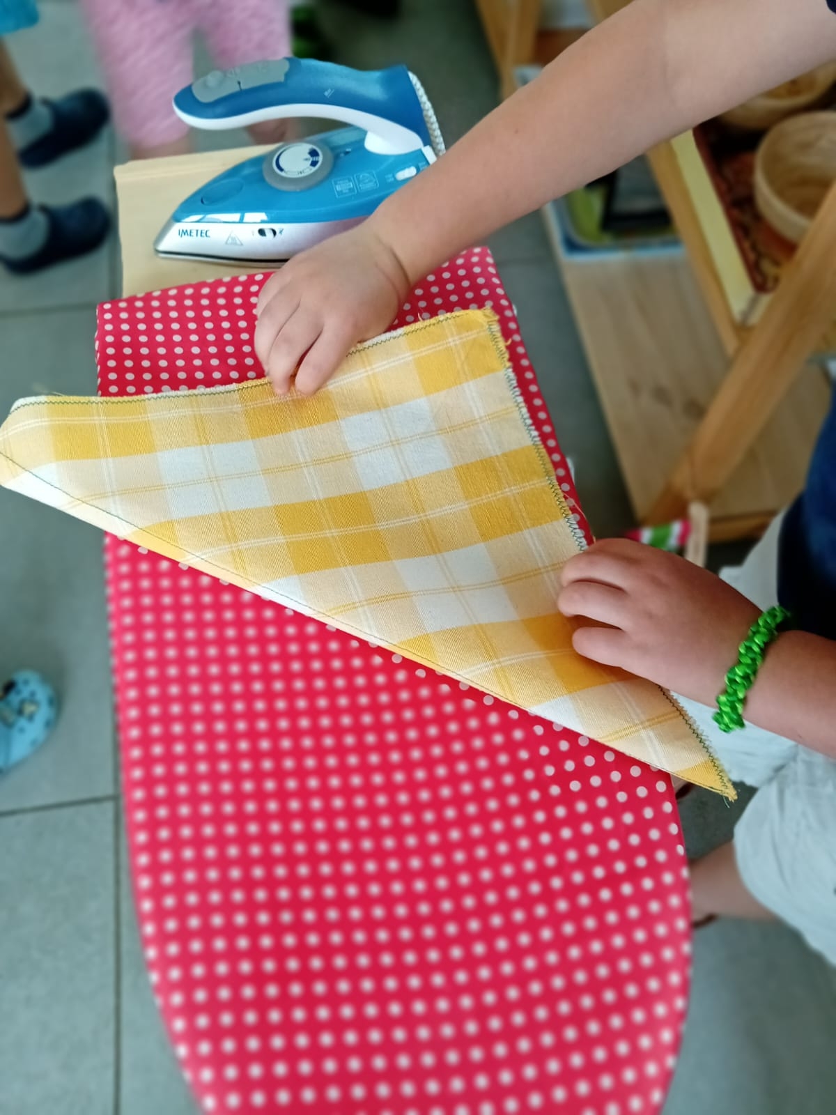 Attività di vita pratica: stiratura e piega di un tovagliolo.
